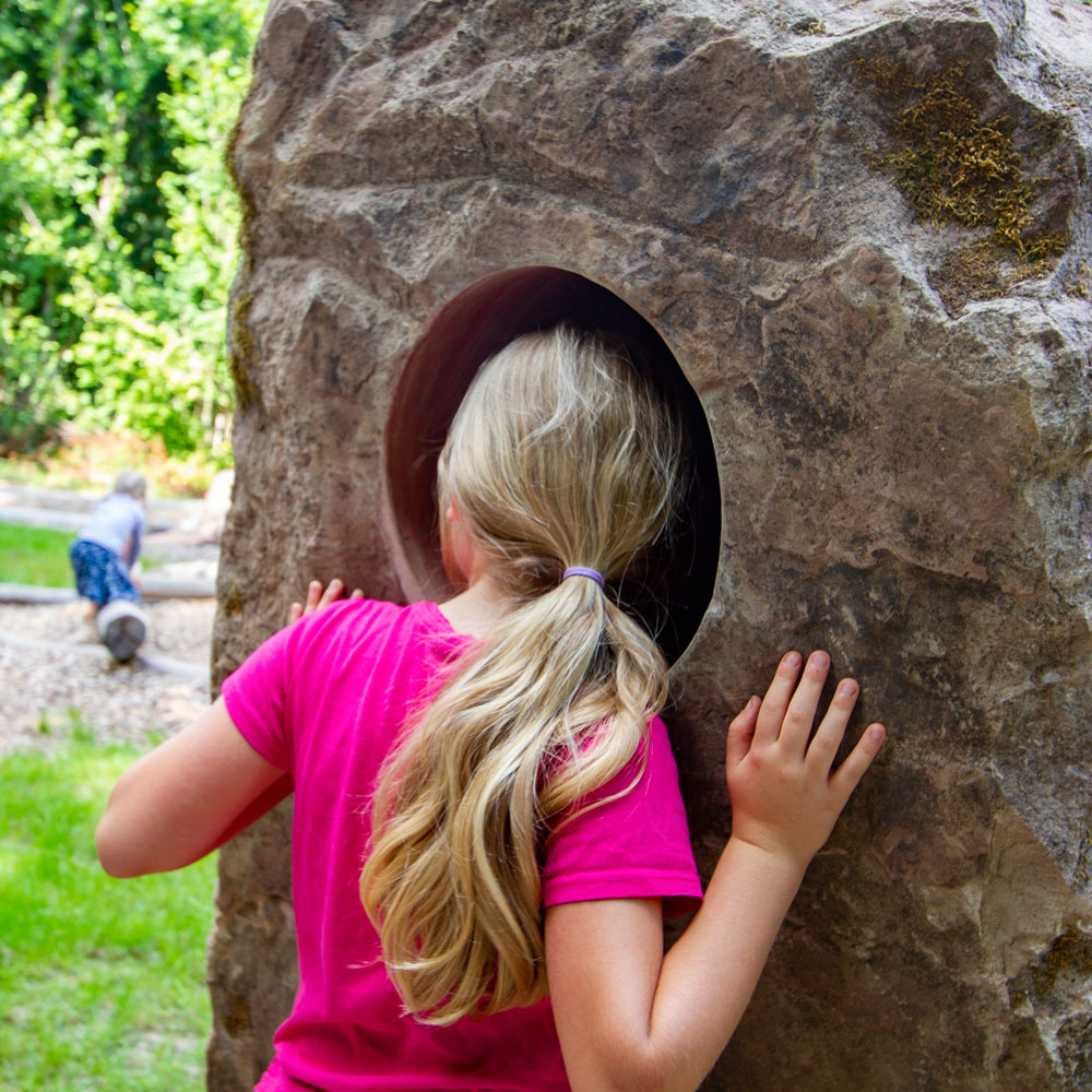 Kind hört in einen Stein