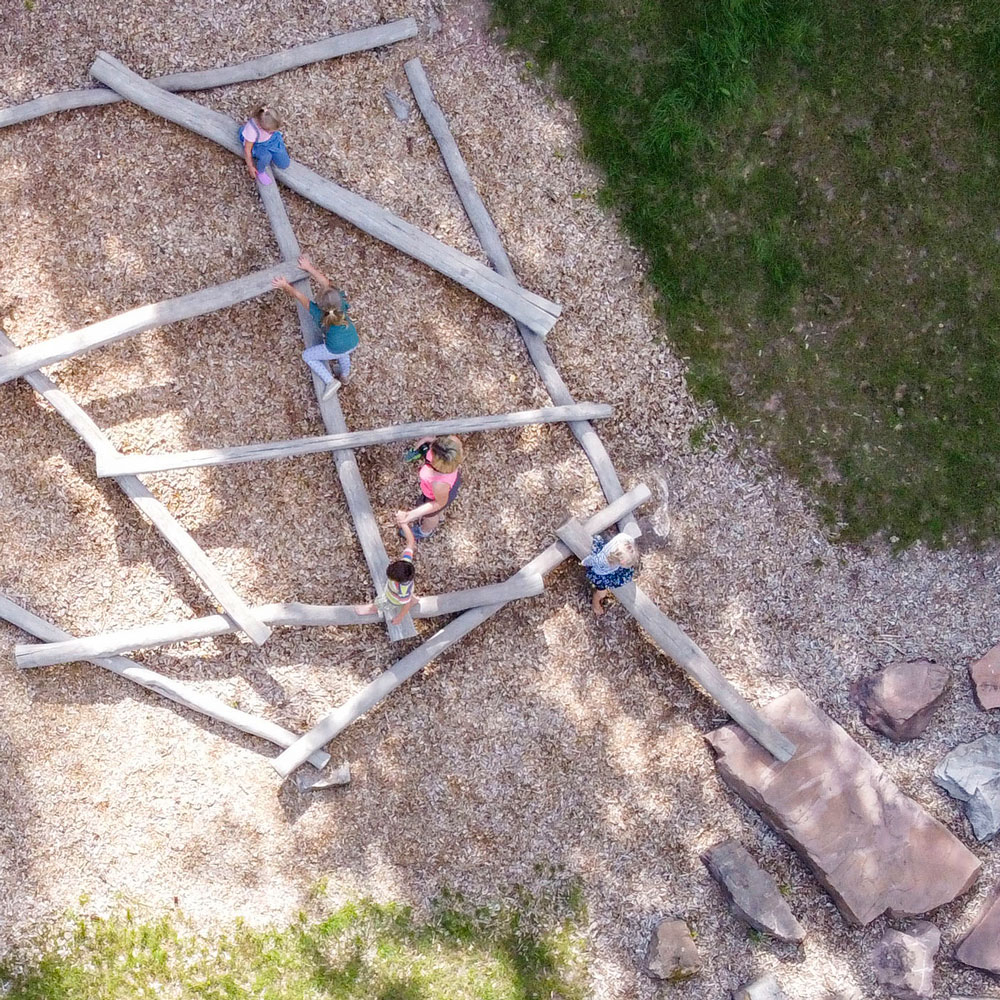 Kinder klettern und Balancieren auf Holzstämmen
